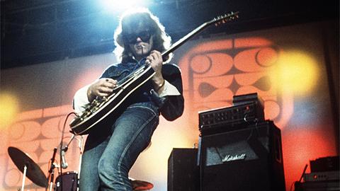 Kitaristi värivalojen välkkeessä.