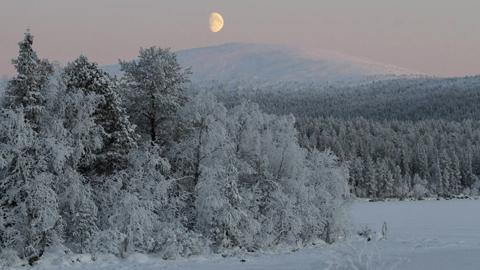 Kuu nousee tunturin takaa.