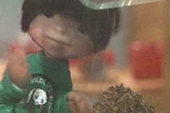 Kuva: Matti-nukke katsoo kuinka akvaariota t�ytet��n hiekalla. YLE kuvanauha.