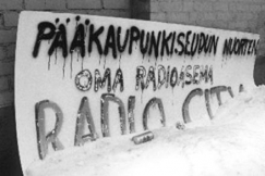 Kuva: Radio Cityn mainoskyltti. 
El�v�n musiikin yhdistys, 
ELMU:n toimitalo.
(1985)
Pentti Palmu