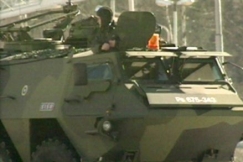 Kuva: Pasi-kuljetusvaunu piiritetyn talon ulkopuolella. YLE kuvanauha.