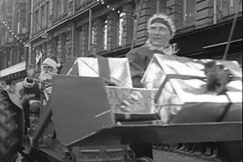 Kuva: Joulupukki ja tonttu ajavat hevosrattailla. YLE kuvanauha. 