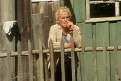 Kuva: Mies nojaa aitaan ja polttaa tupakkaa. YLE kuvanauha.