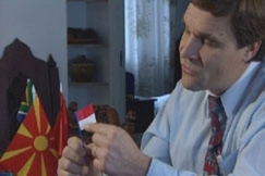 Kuva: Kimmo Kiljunen esittelee lippuja. (1999) YLE kuvanauha.