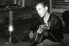 Kuva: Tapio Rautavaara istuu s�ngyll� ja laulaa. (1965) YLE kuvanauha.