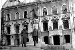 Kuva: Pommitusten vaurioittama Viipurin kaupunginmuseo. Eino Nurmi ja tuntematon luutnantti seisovat Torgils Knuutinpojan patsaan juurella museon edustalla (1941). Eino Nurmi.