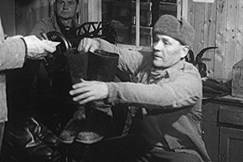 Kuva: Ty�velvollinen Norppa (Uljas Kandolin) ottaa saappaat. YLE kuvanauha.