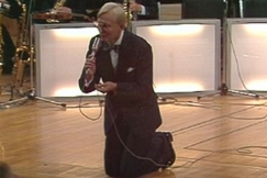 Kuva: Vilho Vartiainen polvistuneena lavalle  (1979). YLE kuvanauha.