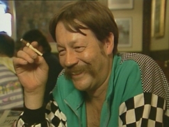 Kuva: Irwin Goodman haastateltavana savuke k�dess��n (1988). Yle kuvanauha.