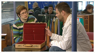Ari Aura, visakoivuinen salkku ja Roman Schatz (copyright YLE/videokuvaa)