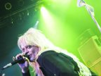 Michael Monroe istumassa lavan reunalla monitorin päällä. 