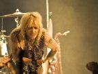 Michael Monroe kumartuneena yleisöä kohti. 