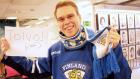 Kuvassa Timppa Leijonien pelipaitaan ja kaulaliinaan sonnustautuneena. Miehellä on kädessään lappu, jossa lukee "Toivo!" ja sen alapuolella sulkeissa elää. Miehellä on leveä virne kasvoillaan.